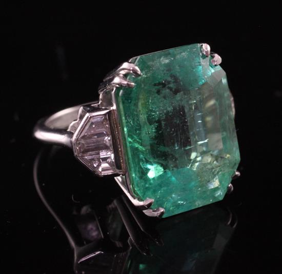 A platinum, emerald and diamond set dress ring, size L.